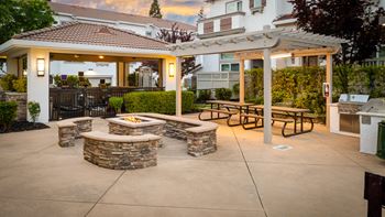 A patio with a fire pit and seating area.